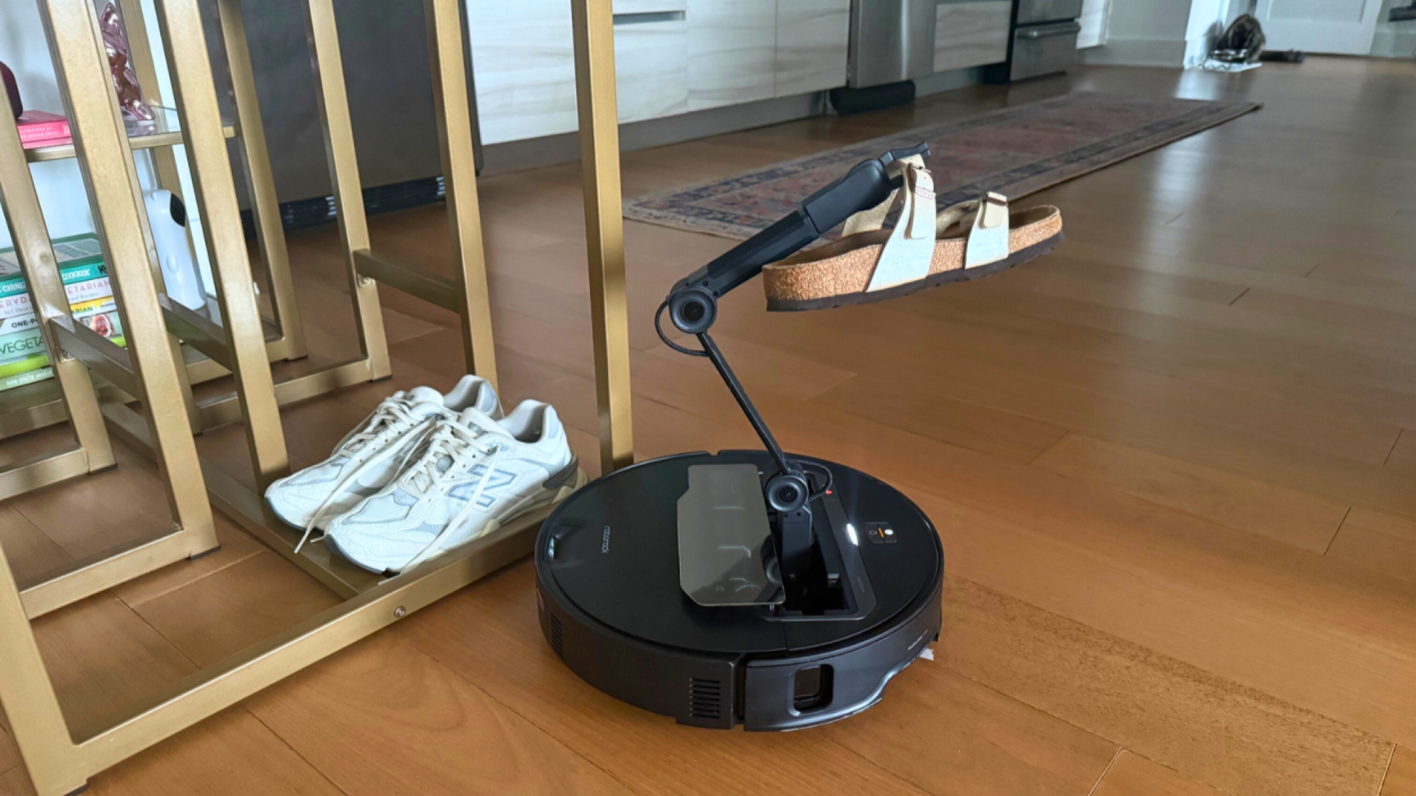 Roborock Saros Z70 robot vacuum picking up a shoe with arm