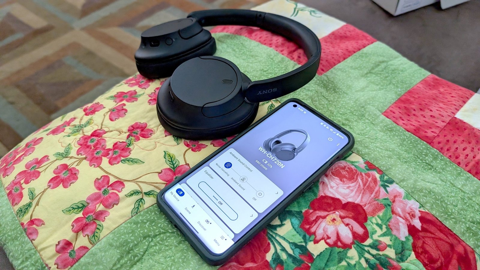 The Sony WH-CH720N headphones in black, lying next to a phone with the Sony Sound Connect app open