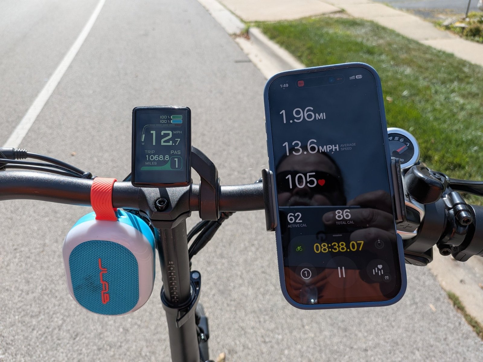 iphone clipped to bike handlebars showing Apple Fitness app and heart rate