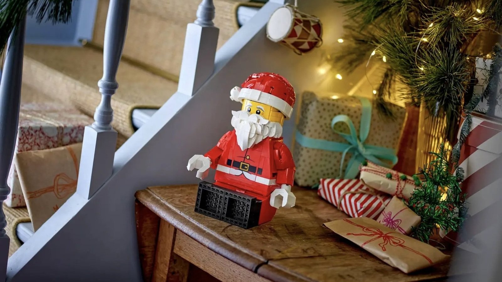 Lego Up-Scaled Santa Minifigure on side table next to other holiday decor