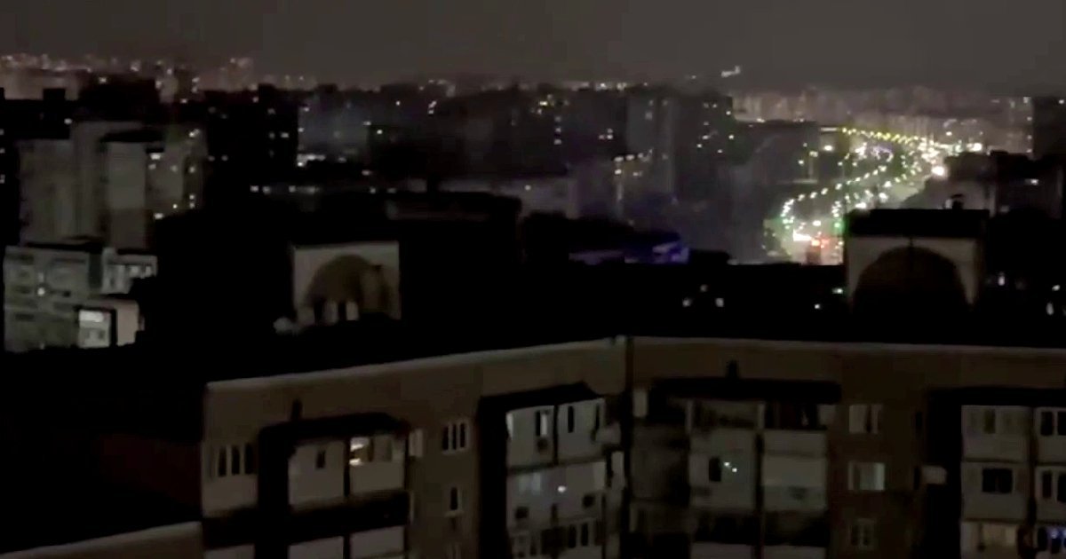 Night view of a city skyline with illuminated buildings and streets, showcasing urban life and architecture under a dark sky.