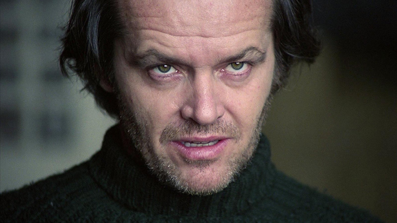 A man in a turtleneck looks creepily just off-camera.