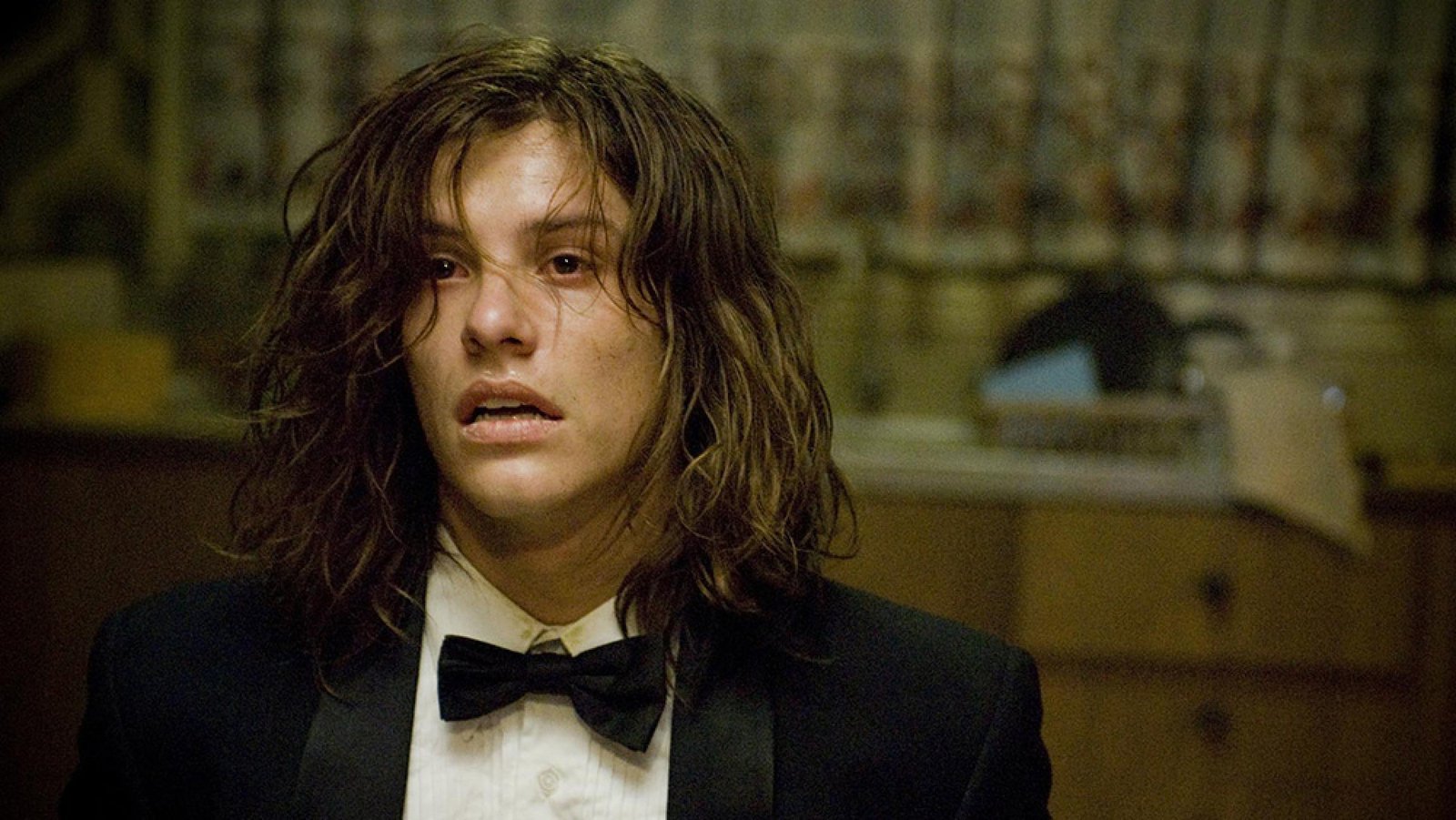 A young man in a tuxedo looks distraught in a home.