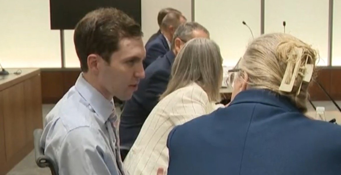 A group of professionals engaged in discussion during a meeting in a modern conference room.