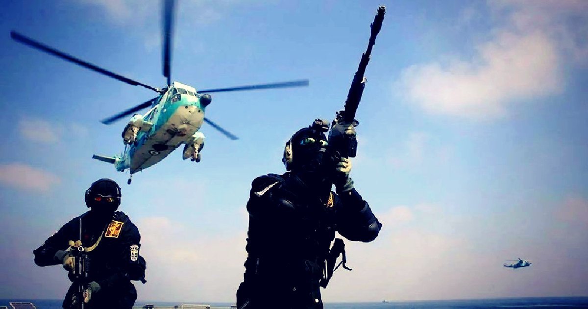Military personnel on a ship engage with helicopters in a tactical training exercise, showcasing teamwork and advanced weaponry in action.