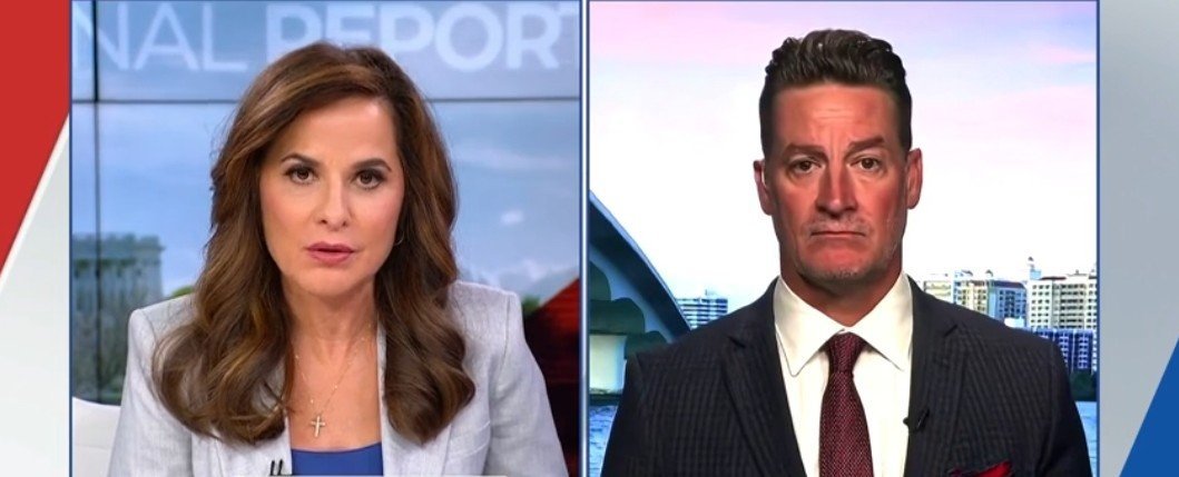News anchors discussing current events on a split-screen broadcast, featuring a woman in a gray blazer and a man in a dark suit.