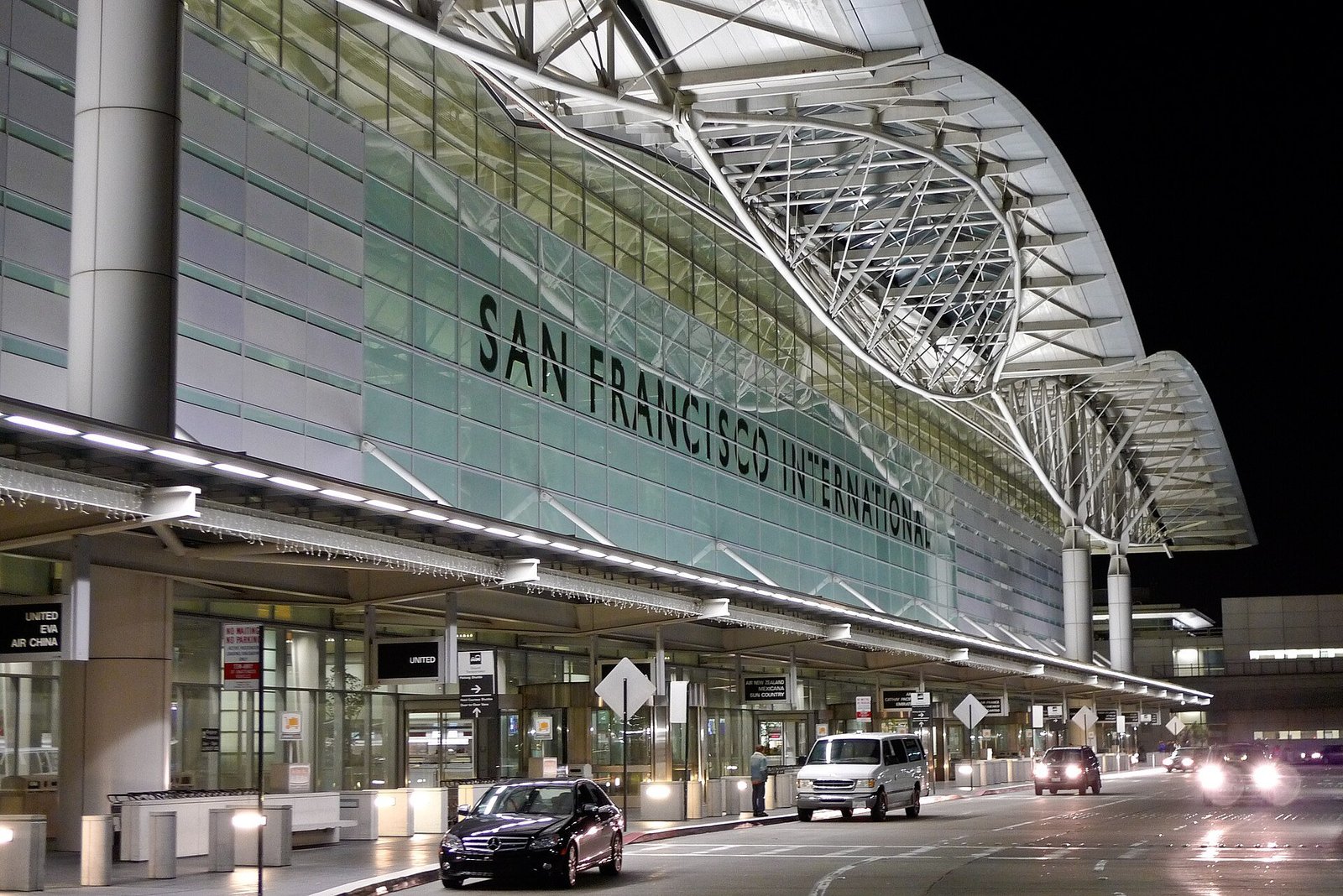 San Francisco International Airport exterior at night, showcasing modern architecture and illuminated signage.